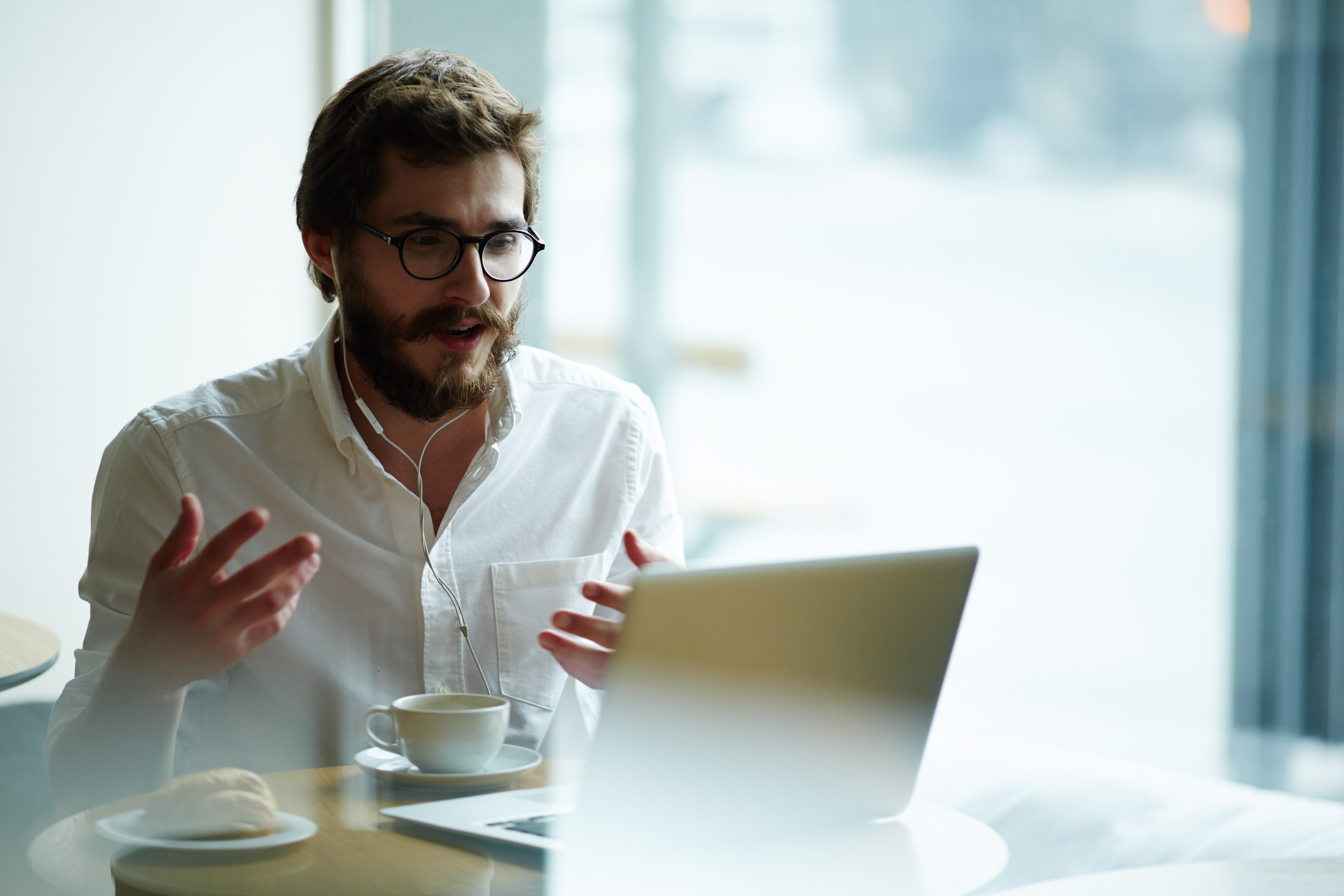 a man on a remote recruiting call sitting in a coffee shop